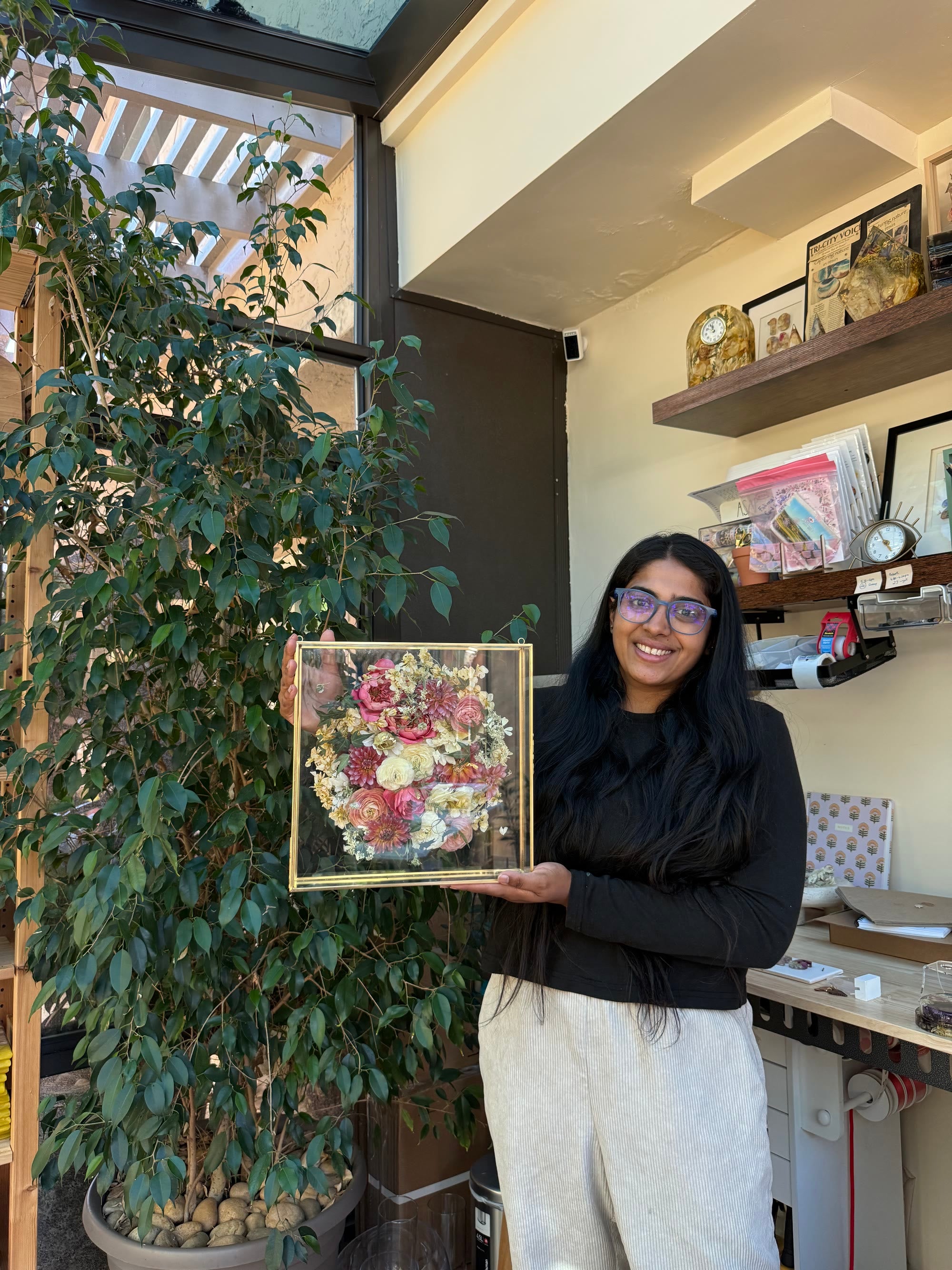 AK holding a framed bridal bouquet preservation